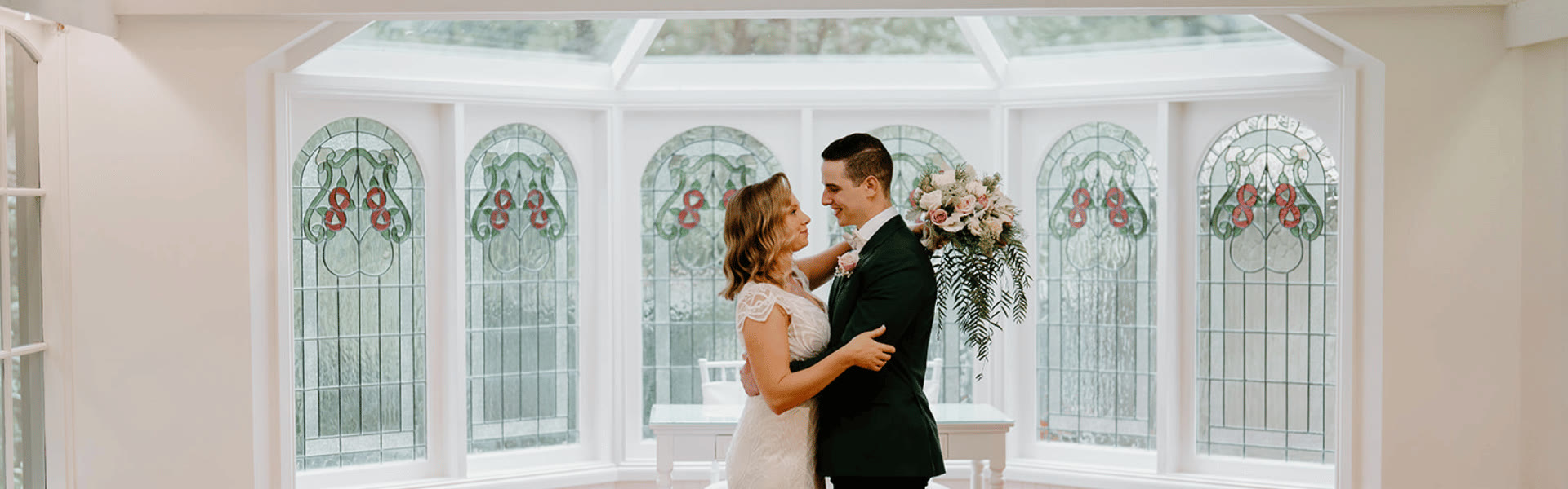 A couple standing before the chapel windows.